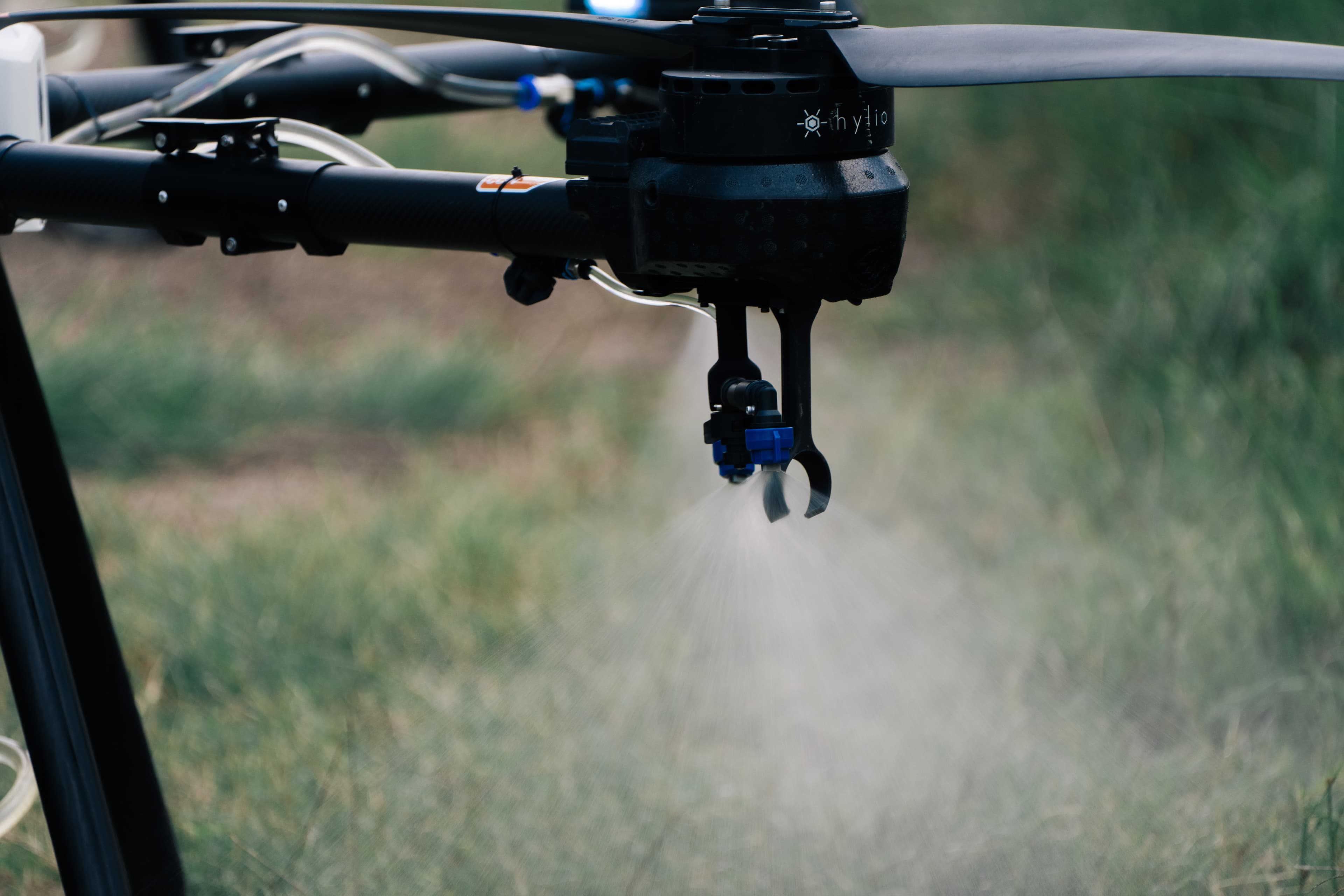 Hylio agricultural spray drone applying product over a field
